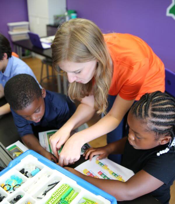 Instructor guiding kids through a robotics build